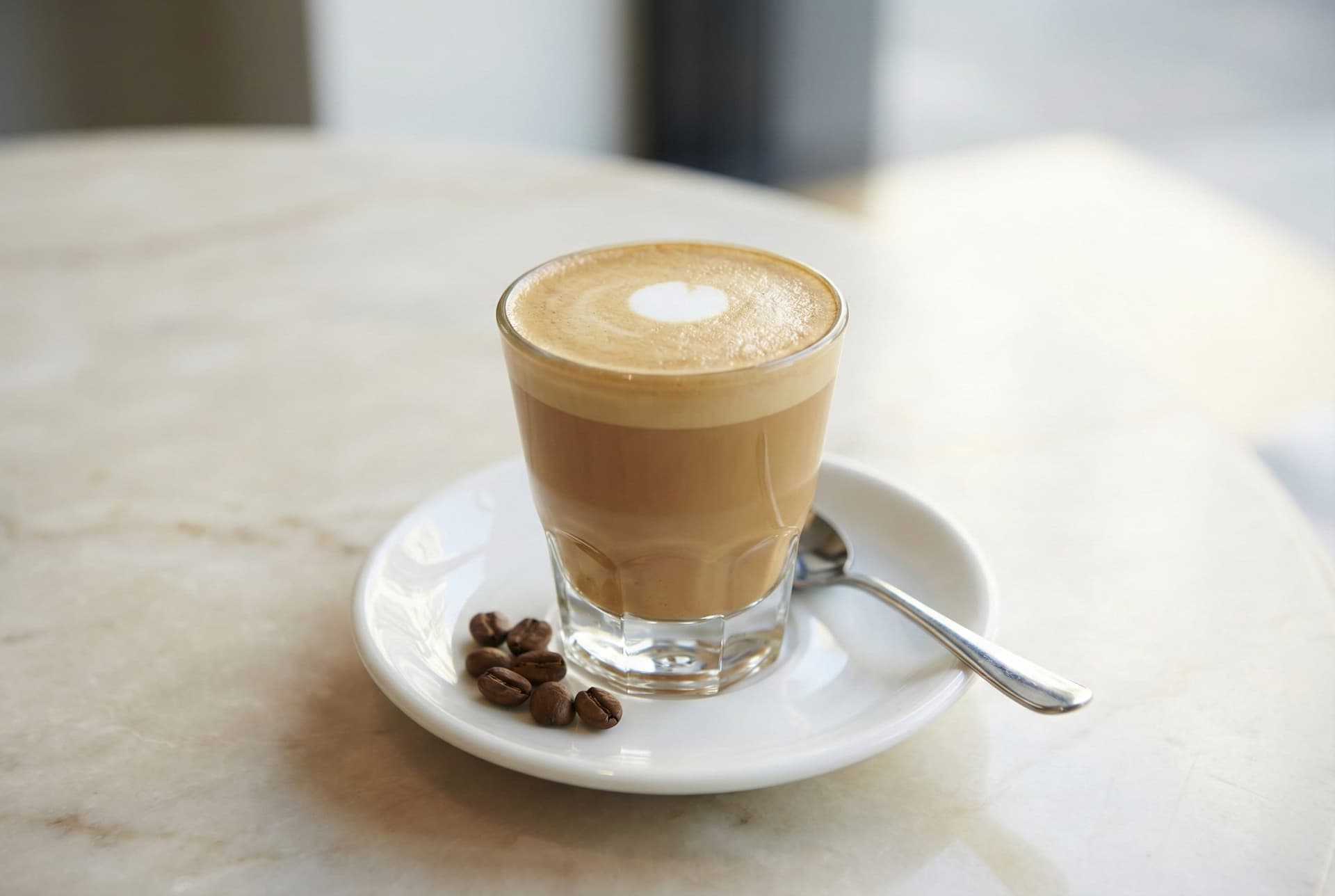 Australian piccolo latte in small demitasse glass showing concentrated espresso with steamed milk - miniature latte alternative perfect for multiple servings throughout the day