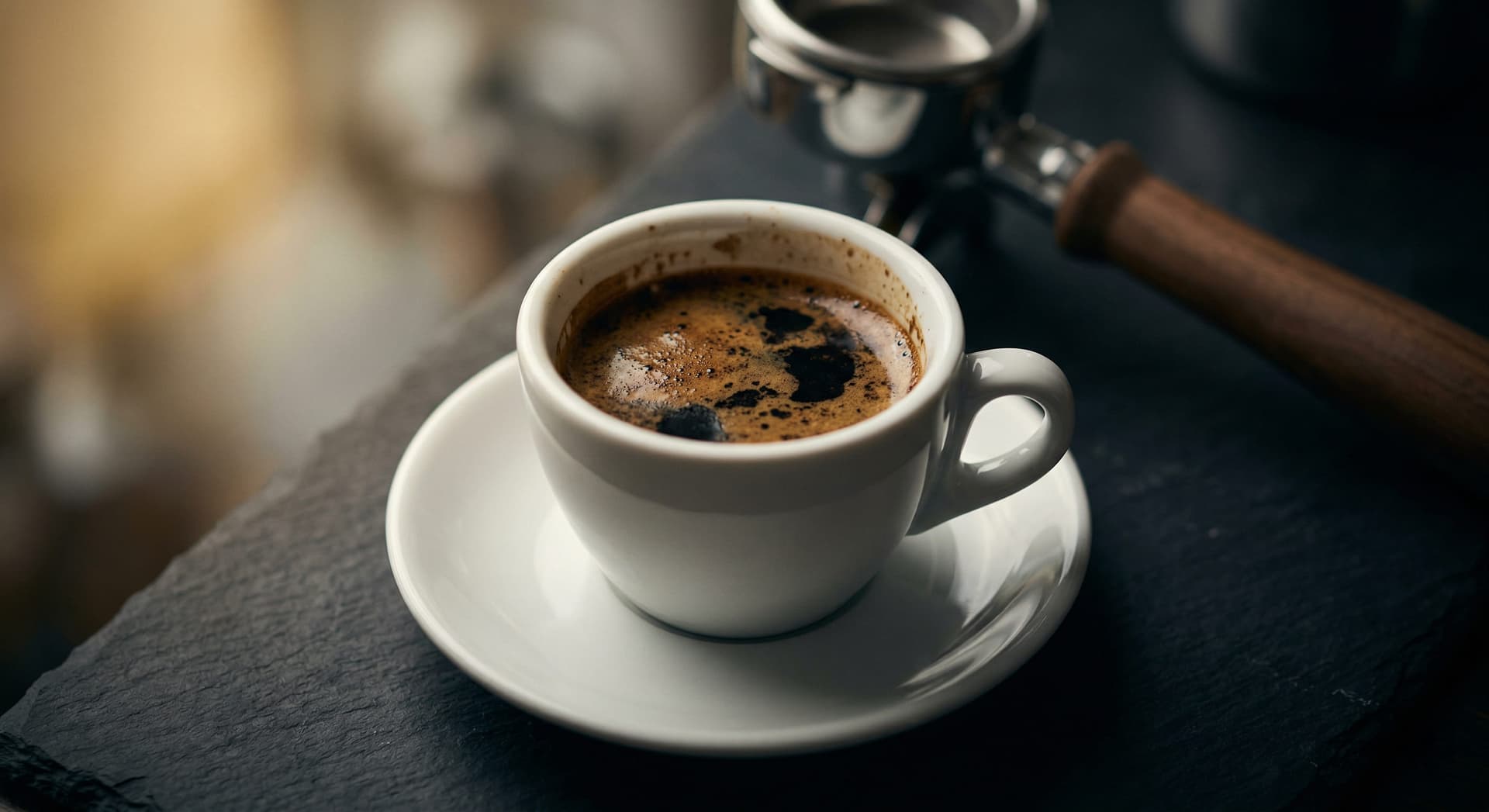 Dark over-extracted espresso shot in white demitasse showing bitter crema — how to fix bitter espresso by adjusting grind, temperature, and dose
