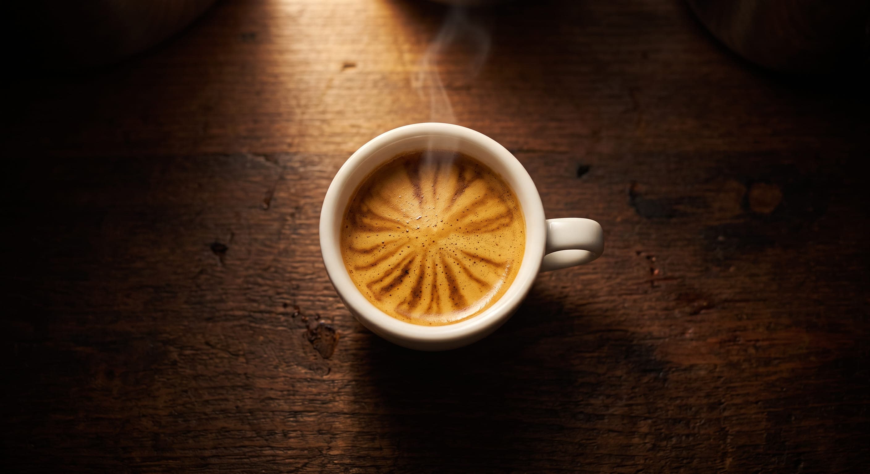 Close-up of a perfectly extracted espresso shot with thick golden crema in a white demitasse cup — how to increase espresso crema guide