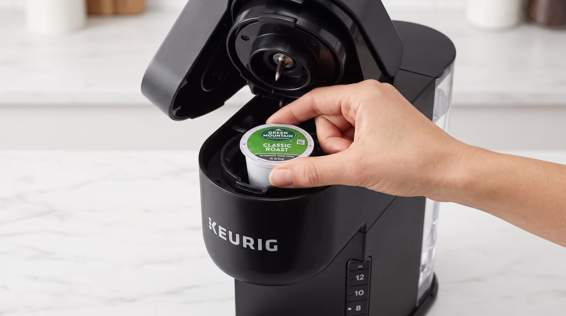 Keurig K-Express K-Cup pod being inserted into the pod holder — simple one-step pod loading process