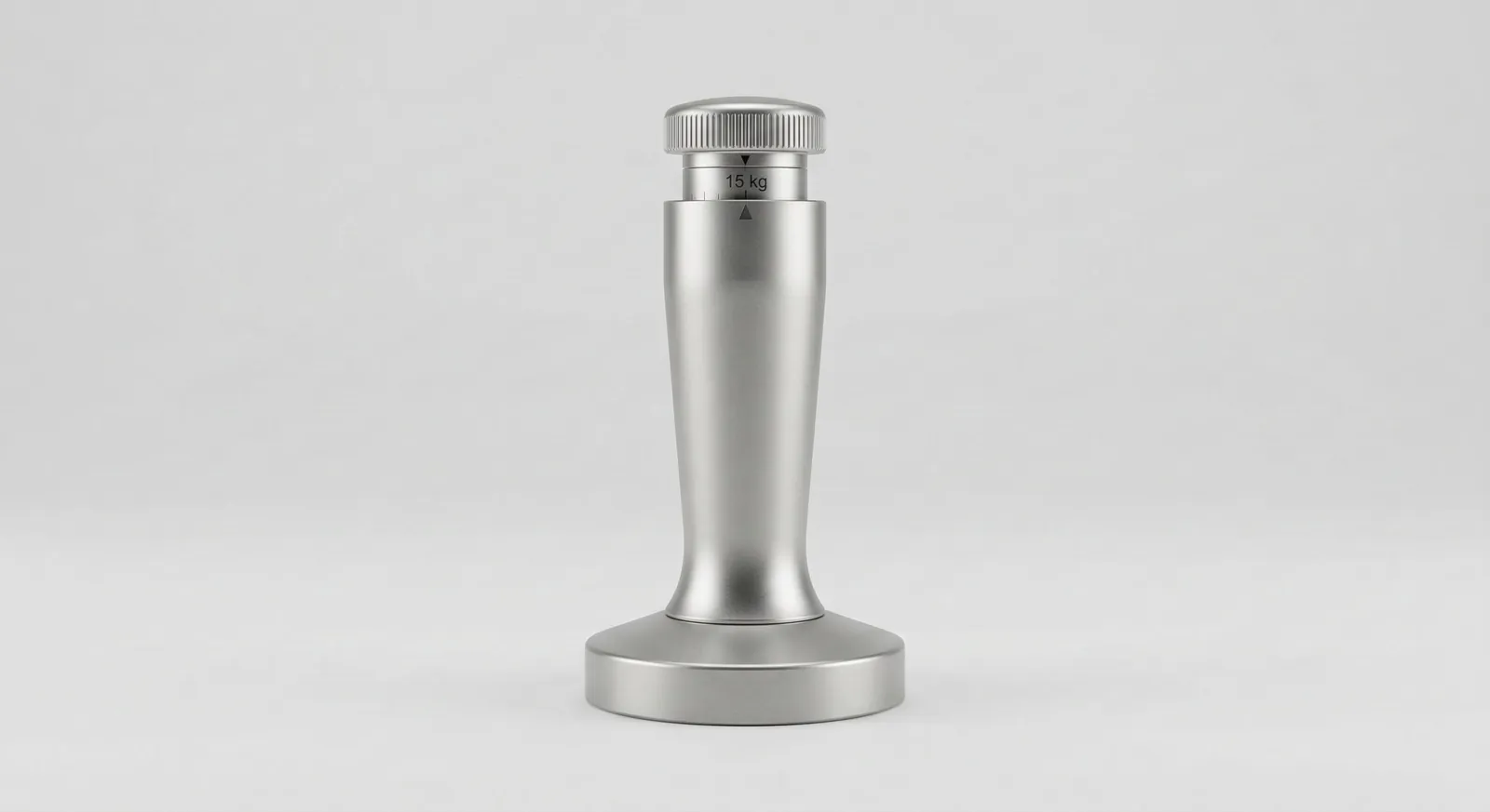 Silver calibrated espresso tamper standing upright on a plain light grey background