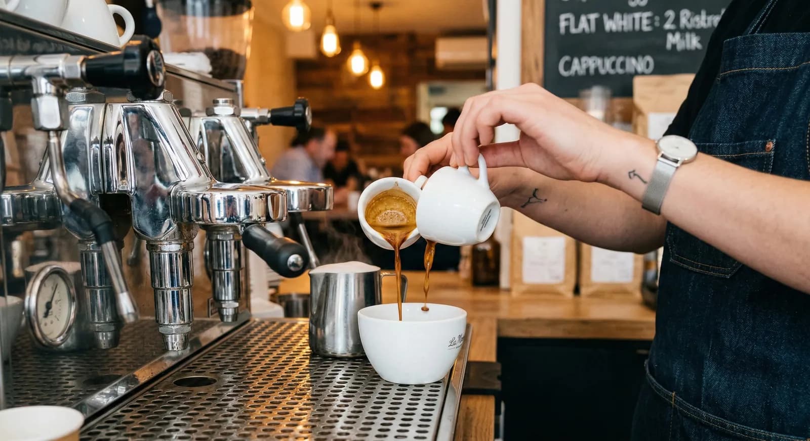 Barista pouring a ristretto shot into a cup at a café counter