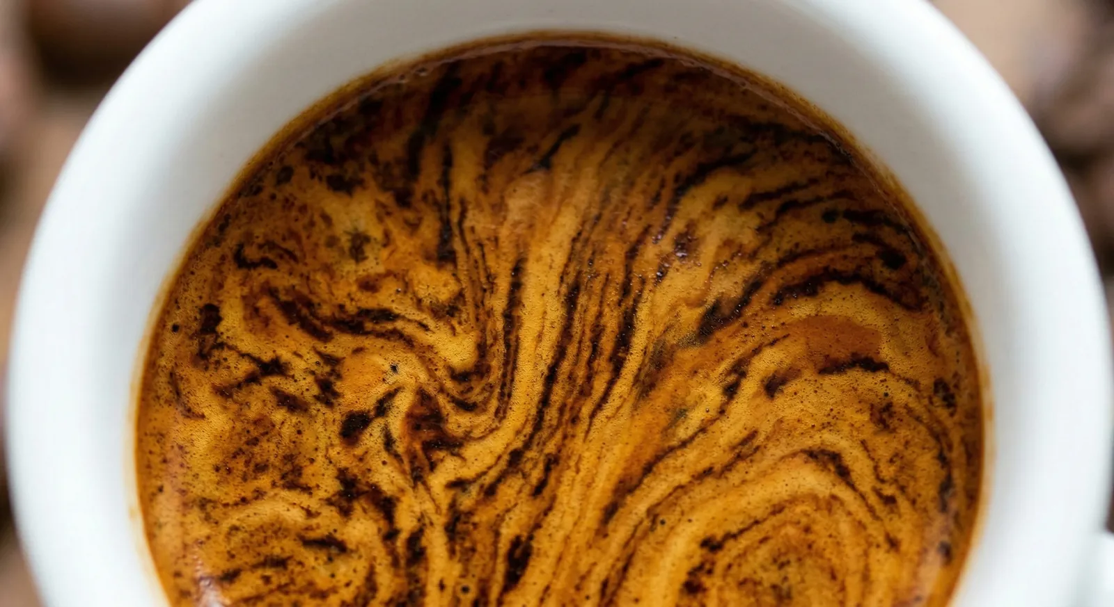 Overhead close-up of a ristretto with dense marbled crema in a white cup