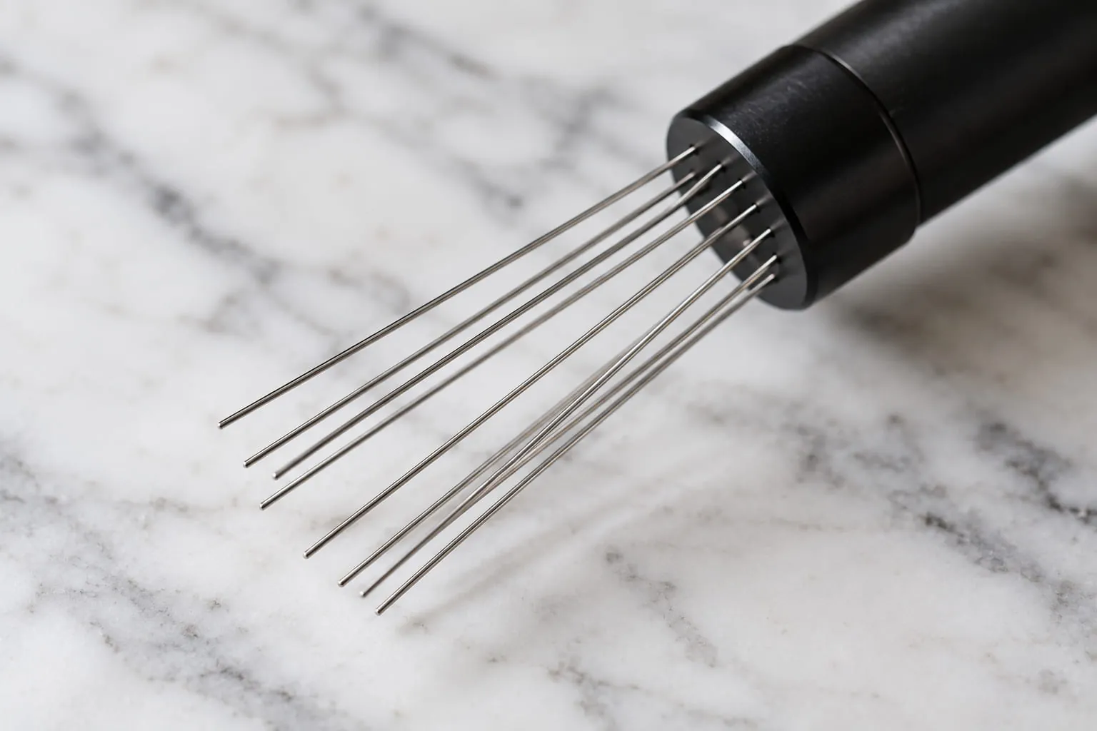 Close-up of a WDT tool with thin stainless needles on a marble surface