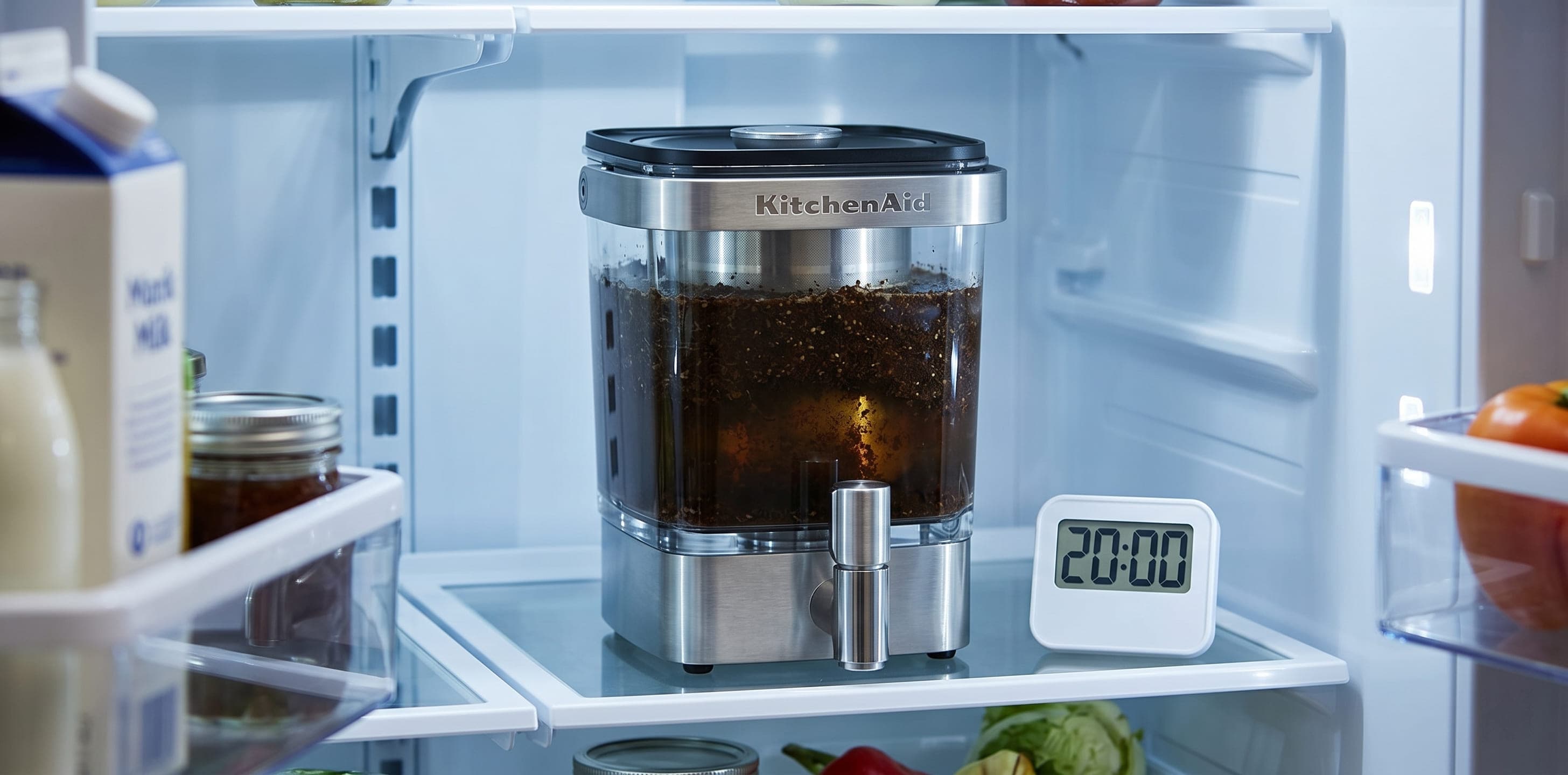 KitchenAid cold brew maker standing upright on a refrigerator shelf while the coffee steeps