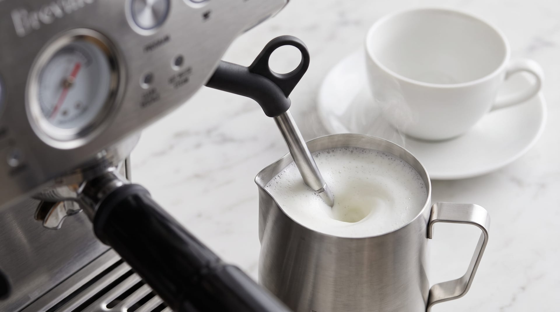 Breville Barista Express BES870XL manual steam wand frothing whole milk in stainless steel pitcher for cappuccino or latte