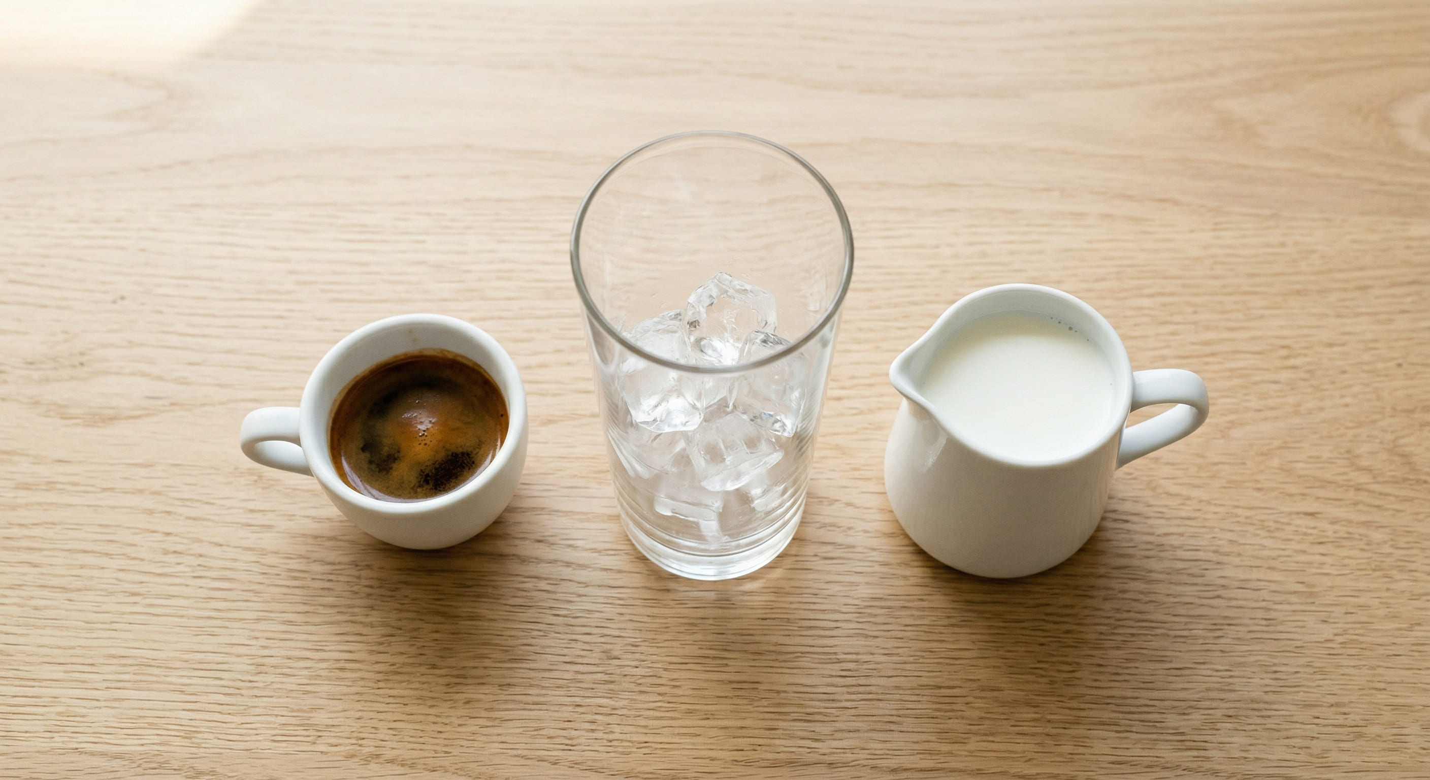 Iced latte ratio diagram showing ice, cold milk, and double espresso layers in a 350 ml glass — homemade iced latte proportions guide