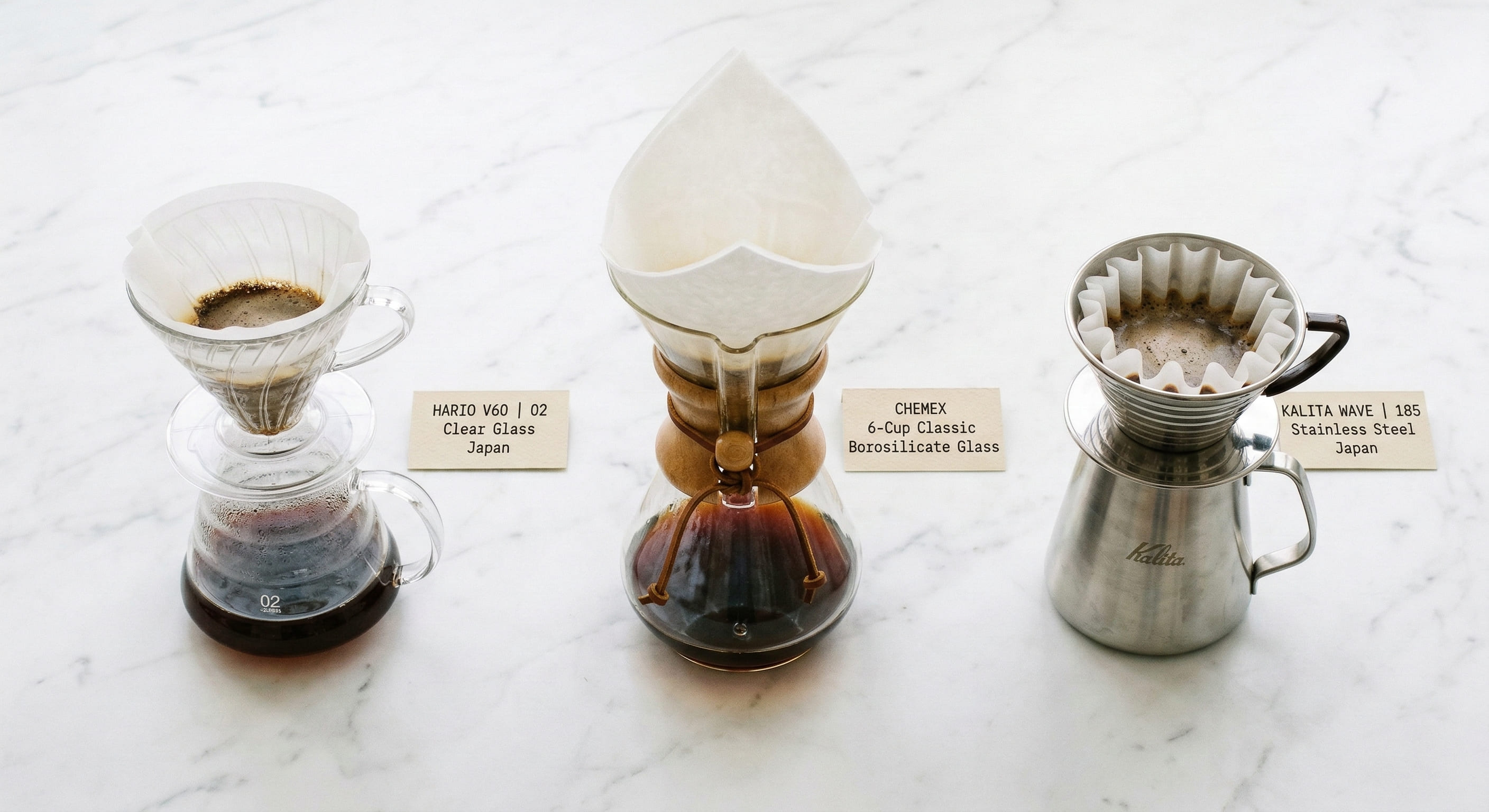 Three pour over drippers compared side by side: Hario V60 (left), Chemex (centre), and Kalita Wave (right) — showing the main filter coffee brewing equipment options
