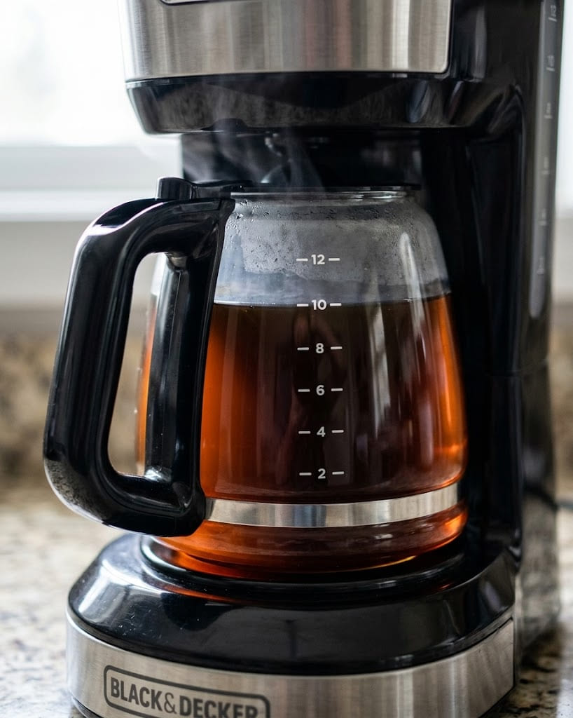 12-cup glass carafe with measurement markings and comfortable handle, sitting on warming hot plate of BLACK+DECKER drip brewer